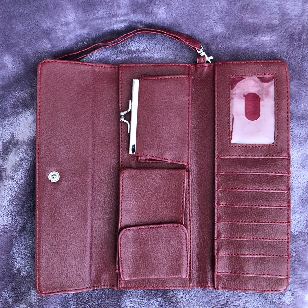 Women’s wallet in a red/burgundy color, with hand strap. Very good condition.